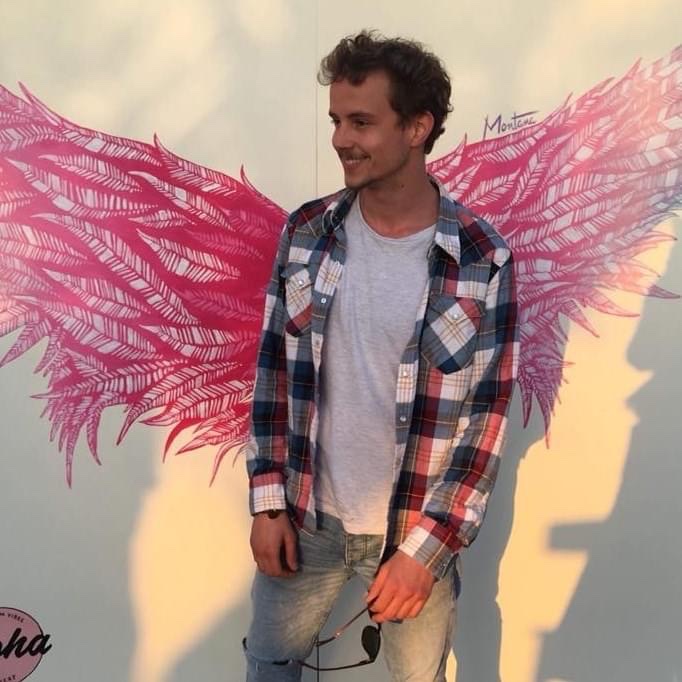 Reeses Track in front of a painted pair of wings